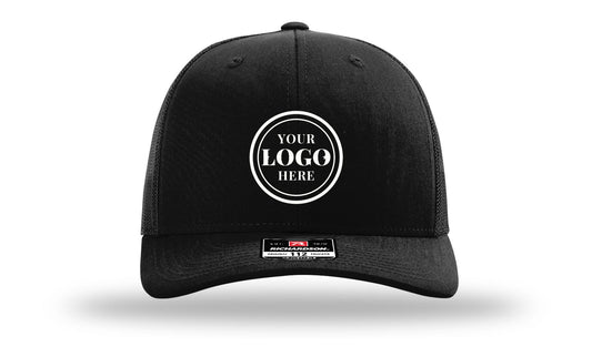 Richardson 112 trucker cap, black, with 2.1 in embroidered logo placeholder centered on front panel